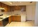 Functional kitchen with wood cabinets, dishwasher, and tiled floor at 4210 W Calavar Rd, Phoenix, AZ 85053