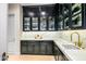 Butler's pantry with dark cabinetry, marble counters, and glass-front cabinets at 42638 N Chiricahua Pass, Scottsdale, AZ 85262