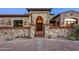 Elegant home exterior with stone accents and arched entryway at 42638 N Chiricahua Pass, Scottsdale, AZ 85262