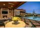 Outdoor patio with fireplace and dining table, pool view at 42638 N Chiricahua Pass, Scottsdale, AZ 85262