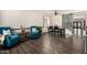 Dining area with teal armchairs, barn door, and dark wood table at 43244 N Heavenly Way, Anthem, AZ 85086