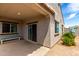 Covered back patio with sliding glass doors, a bench, and a view of a landscaped backyard at 5013 S 112Th Ave, Tolleson, AZ 85353