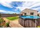 Private backyard featuring a refreshing above ground pool, lush lawn, and a flower bed, perfect for summer fun at 5013 S 112Th Ave, Tolleson, AZ 85353