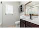 Stylish bathroom featuring modern vanity, dark wood cabinets, barn door cabinet, and neutral wall color at 5013 S 112Th Ave, Tolleson, AZ 85353