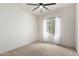 Bright bedroom with neutral carpet, ceiling fan, and white sheer curtains offering serene views at 5013 S 112Th Ave, Tolleson, AZ 85353