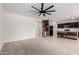 Open-concept living room and kitchen with an island, stainless appliances, and plush carpet at 5013 S 112Th Ave, Tolleson, AZ 85353
