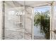 Modern shower with marble tile and a view to backyard at 9412 N 33Rd Way, Phoenix, AZ 85028