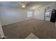 Spacious living room featuring plush carpeting, a ceiling fan, and great natural lighting at 10245 W Jessie Ln, Peoria, AZ 85383