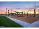 Sunset view of a playground with slides, swings, and shade structures at 10550 E Sanger Ave, Mesa, AZ 85212