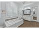 Spa-like bathroom with soaking tub, white cabinets, and tile flooring at 10888 N 136Th Pl, Scottsdale, AZ 85259