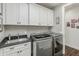 Bright laundry room with white cabinets and granite countertops at 10888 N 136Th Pl, Scottsdale, AZ 85259