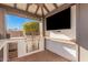 Outdoor kitchen with grill, wine cooler, and large TV at 1211 W Sousa Ct, Anthem, AZ 85086