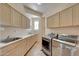 Bright laundry room with washer, dryer, cabinets, and sink at 12238 E Poinsettia Dr, Scottsdale, AZ 85259