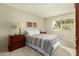 Charming bedroom with striped bedding and a wooden dresser at 12923 W Ballad Dr, Sun City West, AZ 85375