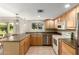 Galley kitchen with light wood cabinets and stainless steel appliances at 12923 W Ballad Dr, Sun City West, AZ 85375