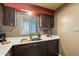 Kitchen features dark cabinets, white countertops and a window at 131 N Higley Rd # 213, Mesa, AZ 85205