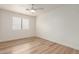 Simple bedroom with light wood floors and a ceiling fan at 1326 W Seascape Dr, Gilbert, AZ 85233