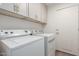 Laundry room with washer, dryer, and gray cabinets at 1326 W Seascape Dr, Gilbert, AZ 85233