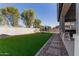 Landscaped backyard with artificial turf, a trampoline, and a paved pathway at 15130 W Linden St, Goodyear, AZ 85338