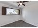 Bright bedroom with ceiling fan, window, and grey carpet at 15202 N 26Th St, Phoenix, AZ 85032