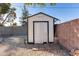 White storage shed with black trim in the backyard at 15202 N 26Th St, Phoenix, AZ 85032