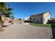 Spacious backyard with pebble landscaping, a swimming pool, and a covered patio at 17338 W Woodrow Ln, Surprise, AZ 85388