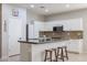 Modern kitchen featuring granite island, white cabinetry, and stainless steel refrigerator at 17338 W Woodrow Ln, Surprise, AZ 85388