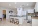 Open kitchen with granite island, white cabinets, and views into adjacent laundry room at 17338 W Woodrow Ln, Surprise, AZ 85388