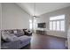 Living room with hardwood floors, sectional sofa, and large TV at 17338 W Woodrow Ln, Surprise, AZ 85388