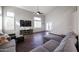 Living room with hardwood floors, sectional sofa, and high ceilings at 17338 W Woodrow Ln, Surprise, AZ 85388