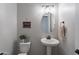 Stylish powder room with pedestal sink and oval mirror at 21097 E Sparrow Dr, Queen Creek, AZ 85142