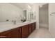 Bathroom with double sinks, wood cabinets, and a bathtub at 2128 E Leo Pl, Chandler, AZ 85249