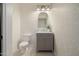 Stylish powder room with gray vanity, patterned wallpaper, and arched mirror at 2128 E Leo Pl, Chandler, AZ 85249