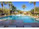 Sparkling community pool with surrounding lounge chairs and palm trees at 21320 N 56Th St # 1175, Phoenix, AZ 85054