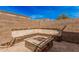 Outdoor seating area featuring a built-in fire pit and stone bench, nestled within a secure walled backyard at 2172 W Pinkley Ave, Coolidge, AZ 85128