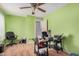 Green bedroom with a ceiling fan, hardwood floors, and a black desk at 2172 W Pinkley Ave, Coolidge, AZ 85128