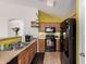 Kitchen showcasing wooden cabinets, modern black appliances, and a breakfast bar to the dining room at 2172 W Pinkley Ave, Coolidge, AZ 85128