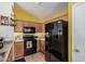 Close up of the kitchen shows wooden cabinets, black appliances, and a view of the refrigerator at 2172 W Pinkley Ave, Coolidge, AZ 85128