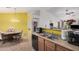 The kitchen and dining area includes wood cabinets, a dishwasher, a coffee maker and views into the living room at 2172 W Pinkley Ave, Coolidge, AZ 85128