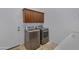 Bright laundry room with modern washer, dryer, and wood cabinets at 2181 W Thompson Pl, Chandler, AZ 85286