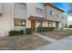 Tan two-story stucco townhome with a brown door and landscaping at 225 N Standage -- # 77, Mesa, AZ 85201