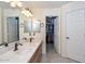 Well-lit bathroom featuring double sinks, walk-in closet, and neutral decor at 23046 N 21St St, Phoenix, AZ 85024