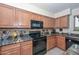 Close-up of kitchen features granite countertops, a black oven, and wooden cabinets at 23046 N 21St St, Phoenix, AZ 85024