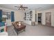 Spacious living room featuring a built-in bookcase, ceiling fan, and large windows with blue curtains at 23046 N 21St St, Phoenix, AZ 85024