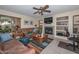 Comfortable living room features a fireplace, TV, ceiling fan, and built-in shelving at 23046 N 21St St, Phoenix, AZ 85024