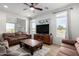 Living room with brown sofas and a large TV at 27606 W Tonopah Dr, Buckeye, AZ 85396