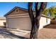 Tan house with a two-car garage and desert landscaping at 34717 N Picket Post Dr, Queen Creek, AZ 85142