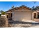 Tan house with a two-car garage and desert landscaping at 34717 N Picket Post Dr, Queen Creek, AZ 85142