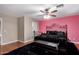 Primary bedroom with a large bed and pink accent wall at 544 W Sierra Madre Ave, Gilbert, AZ 85233