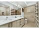 Modern bathroom with double sinks, a shower, and built-in shelving at 7120 E Kierland Blvd # 311, Scottsdale, AZ 85254